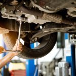 Mechanic is turning the nut to fix the car in the garage repair service scaled